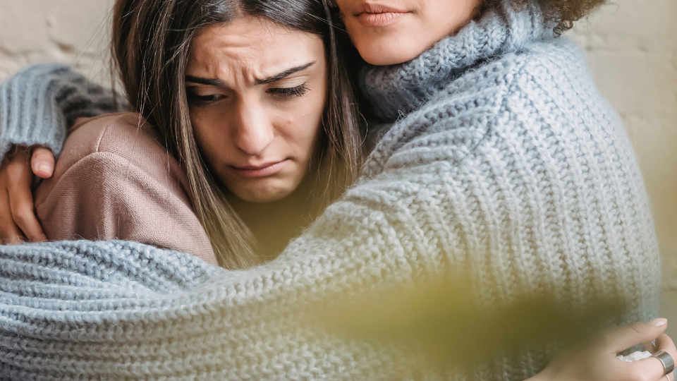 ragazza che piange abbracciata ad un'altra ragazza