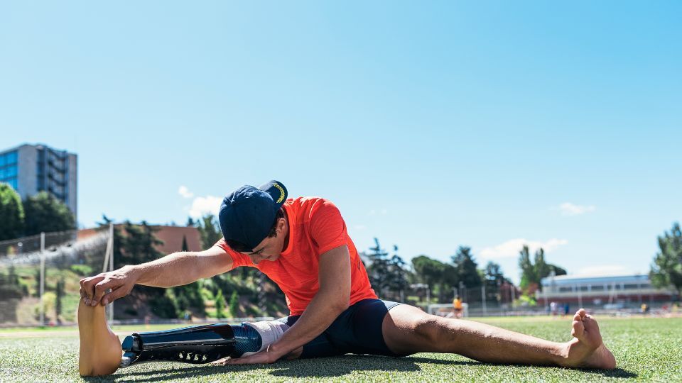 ragazzo con protesi che fa stretching